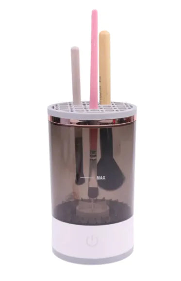 Portable Electric Makeup Brush cleaner with various makeup brushes in the cleaning chamber.